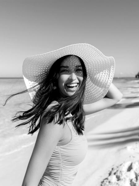 Monochrom-Bild, das eine lachende Frau im Badeanzug an einem Traumstrand zeigt